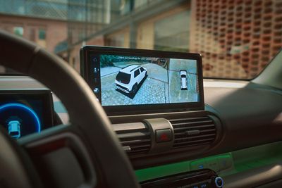 Dashboard display showing surround-view 360 camera with top-down and side parking views.