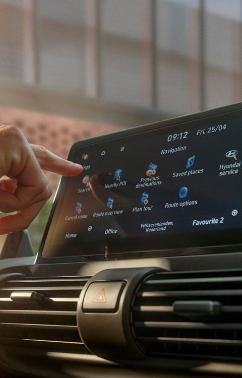 Hand touching the center touchscreen to navigate menus and map options on the INSTER display.