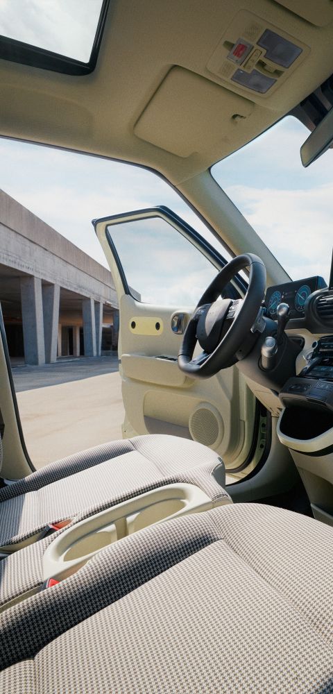 Interior view of front seats and steering wheel of the Hyundai INSTER small electric car, door open.