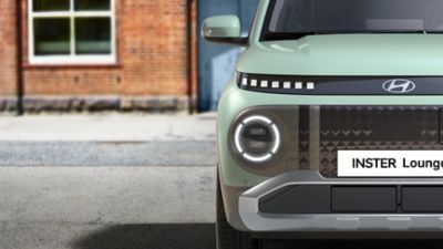 Close up of the bi-colour front grille and round LED daytime running lights of INSTER Lounge.