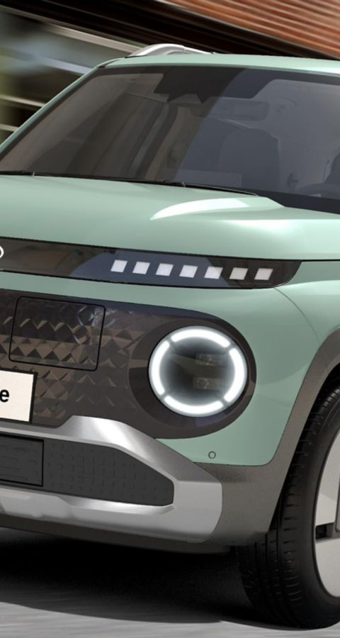 The Hyundai INSTER Lounge in Glow Mint exterior colour driving on a city street.