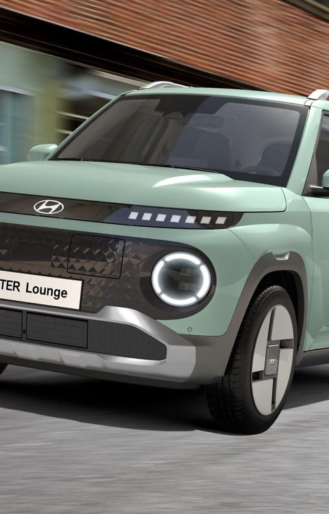 The Hyundai INSTER Lounge in Glow Mint exterior colour driving on a city street.
