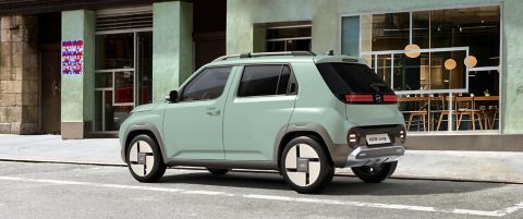 The Hyundai INSTER Lounge in Glow Mint parked on the city street.