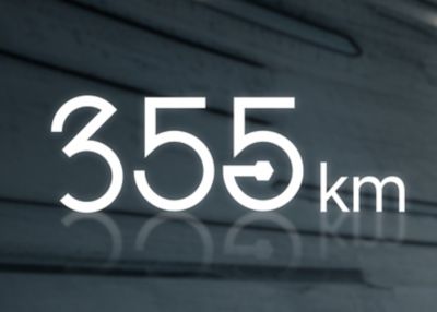  The driving range number of 355 km in white lettering a grey background.