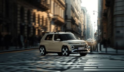 Hyundai INSTER small electric car driving around a corner in a city.