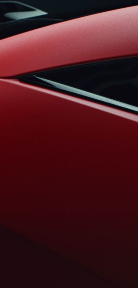 Red Hyundai IONIQ 3 C‑pillar close-up highlighting smooth exterior design lines.