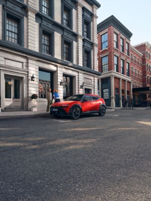 KONA Hybrid Nouvelle génération bleu garé à côté d’un homme portant une chemise jaune.