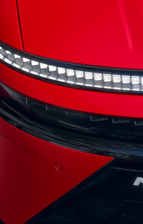 Red Hyundai IONIQ 3 front detail showing slim LED light strip and N Line badge on sculpted body.
