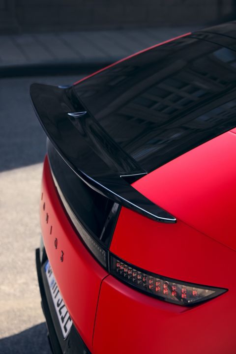 Red Hyundai IONIQ 3 rear detail with black roof spoiler and pixel-style LED taillight design.