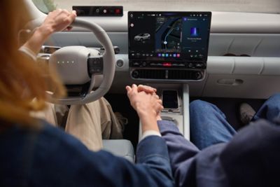 2 personnes dans l’IONIQ 3 qui déjeunent dans leur voiture.
