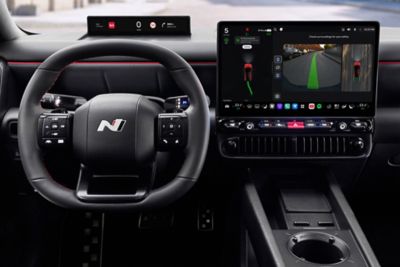 Close up of N Line steering wheel, center display inside the black Hyundai IONIQ 3 N Line interior.