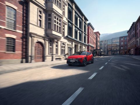 Hyundai IONIQ 3, der durch eine von historischen Gebäuden gesäumte Stadtstraße fährt.
