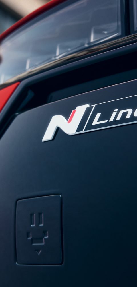 Close up image of the N Line badge on the front bumper of a red Hyundai IONIQ 3 N Line.