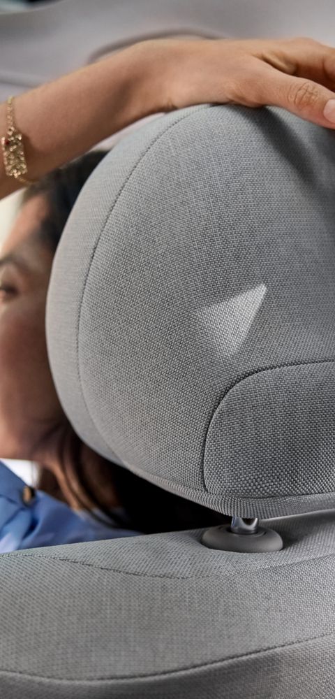 Close up of two people holding hands over the passenger seat headrest of the Hyundai IONIQ 3.