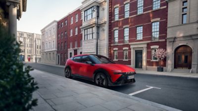 Red Hyundai IONIQ 3 N Line parked on a city street in front of attractive old buildings.
