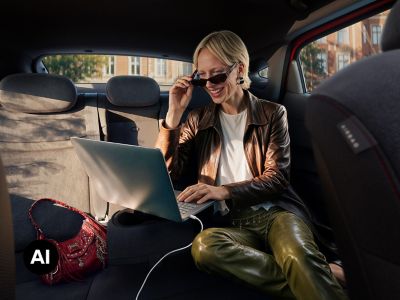 A woman using a laptop in the spacious rear cabin of a Hyundai IONIQ 3.