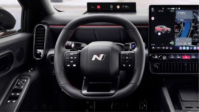 Close up of N Line steering wheel, center display inside the black Hyundai IONIQ 3 N Line interior.