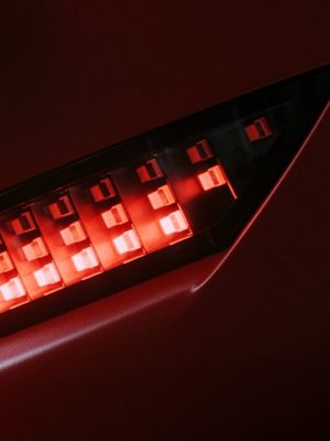 Red Hyundai IONIQ 3 rear light close-up showing illuminated pixel-style LEDs.