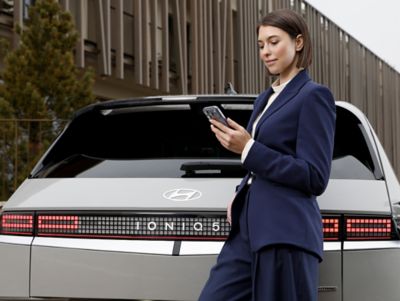 Hyundai IONIQ 5 owner using smartphone connectivity and Bluelink connected car services.