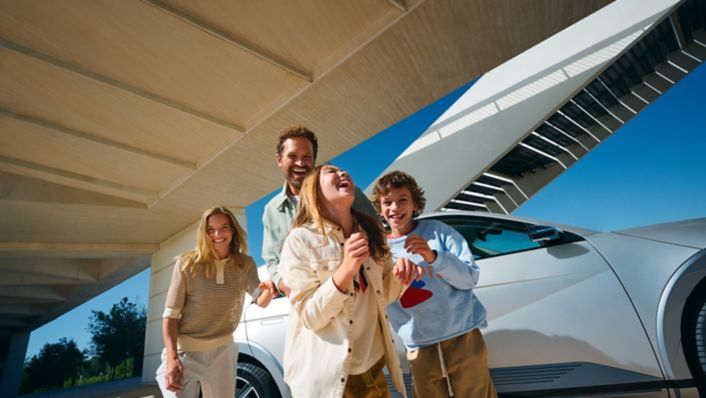 Rodičia s detmi stojaci pred strieborným Hyundai IONIQ 5