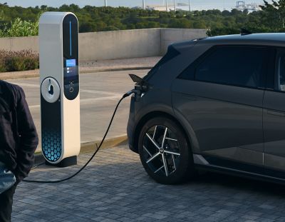 The Hyundai IONIQ 5 being charged at a charging station.