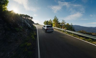 The Hyundai IONIQ 5 N Line full electric vehicle driving down a country road.  