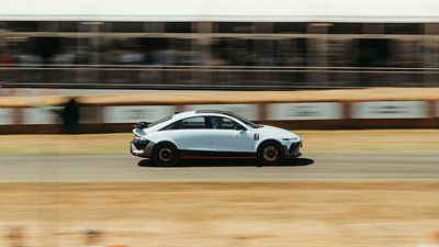 The Hyundai IONIQ 6 N driving at speed on a track during an event