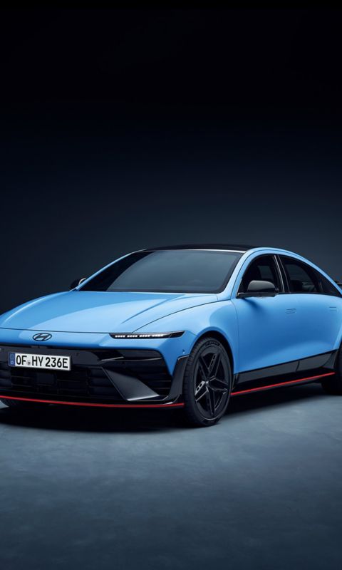 Front quarter view of Hyundai IONIQ 6N in studio setting, showcasing bold grille and sporty stance.
