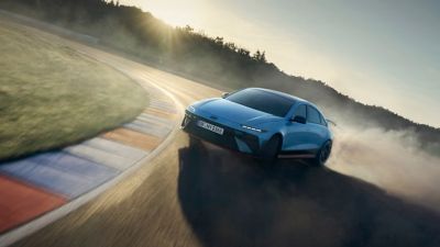 Een Hyundai IONIQ 6 N driftend door een bocht op het circuit.