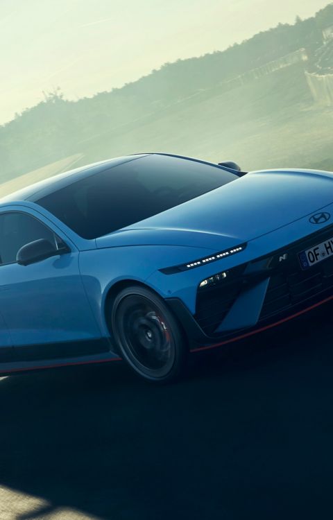 The Hyundai IONIQ 6 N navigating a turn on a racetrack, showcasing its sleek design and performance.