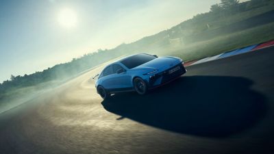Een Hyundai IONIQ 6 N rijdend door een bocht op het circuit, getoond driekwart van voren.