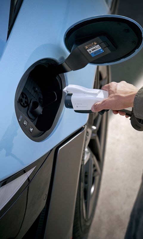 Close-up of a person plugging a charging cable into the Hyundai IONIQ 6 N charging port.