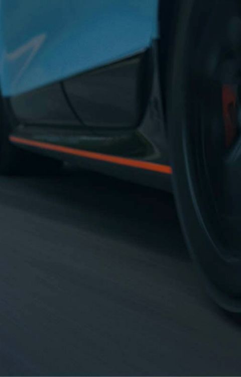 Detailní pohled na boční profil modelu IONIQ 6 N při jízdě po trati, zdůrazňující jeho aerodynamické prvky.