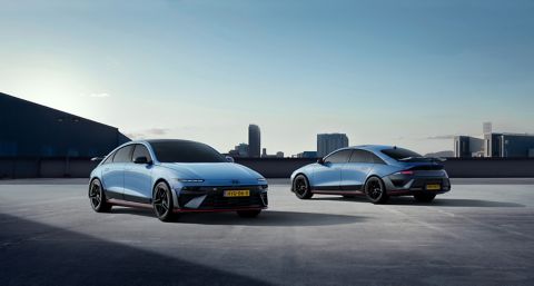 Twee exemplaren van de Hyundai IONIQ 6 N geparkeerd op een dakterras, met op de achtergrond de skyline van een stad.