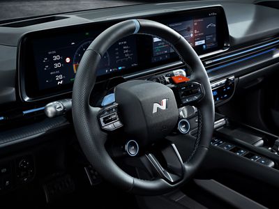 Interior view of IONIQ 6 N steering wheel, featuring digital displays and advanced controls.