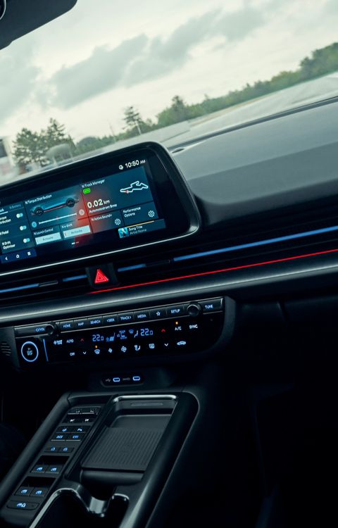 Gros plan sur le cockpit de la IONIQ 6 N pendant la conduite, avec un accent particulier sur l'interface numérique interactive.