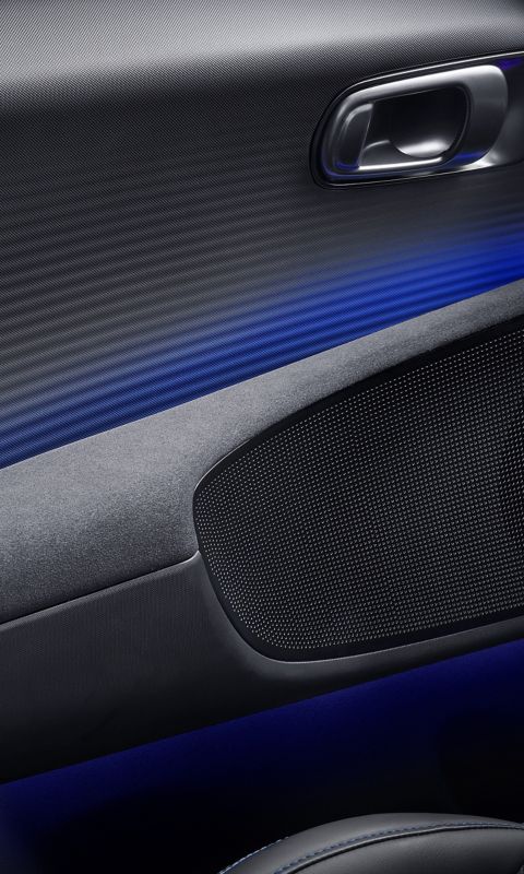 Suede door armrest and modern door controls with ambient lighting inside the Hyundai IONIQ 6 N.