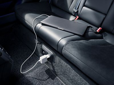 Laptop charging via built-in outlet on the rear seat of a Hyundai IONIQ 6 N.
