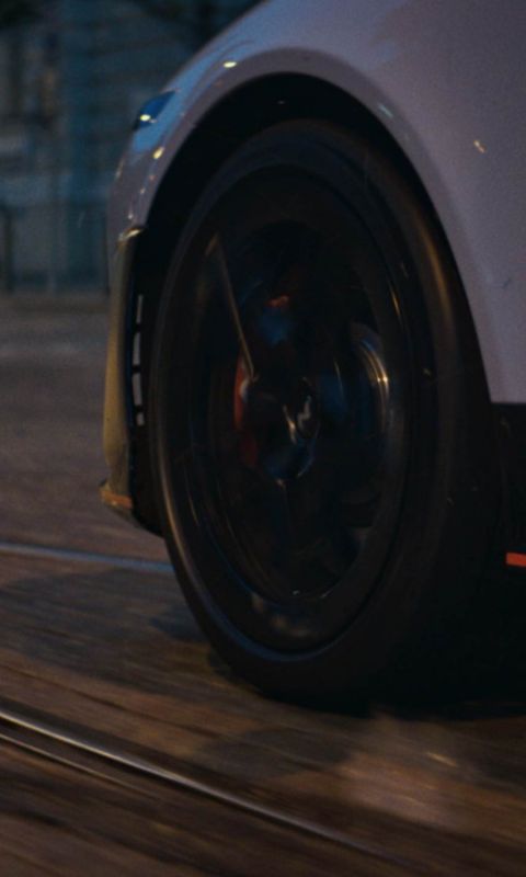 Motion shot of the Hyundai IONIQ 6 N's wheel as it navigates a city landscape, emphasizing dynamic performance.