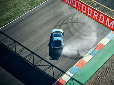 Sicht von oben auf den Hyundai IONIQ 6 N, wie er als elektrisches High-Performance-Fahrzeug enge Donuts auf der Rennstrecke driftet .