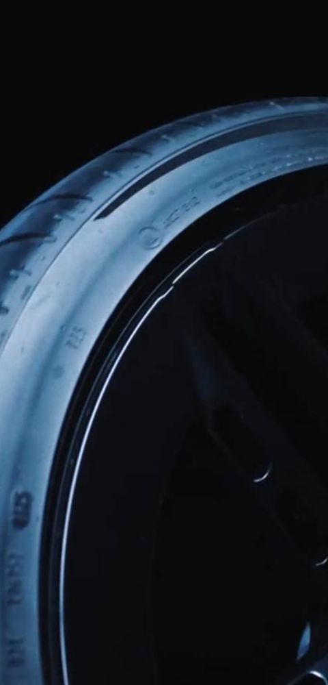 Close-up of a tire on the Hyundai IONIQ 6 N, showcasing its design and tread pattern against a dark background.
