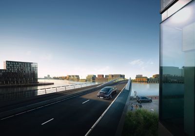 IONIQ 6 driving over a city bridge with IONIQ 5 charging in the background.