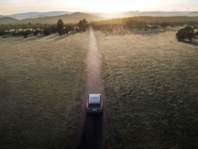 Hyundai IONIQ 9 SUV elettrico che percorre una strada sterrata vista dall’alto.