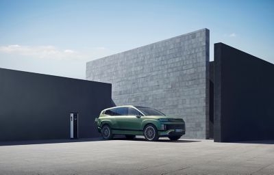 Hyundai IONIQ 9 electric SUV plugged into charge in front of a house.