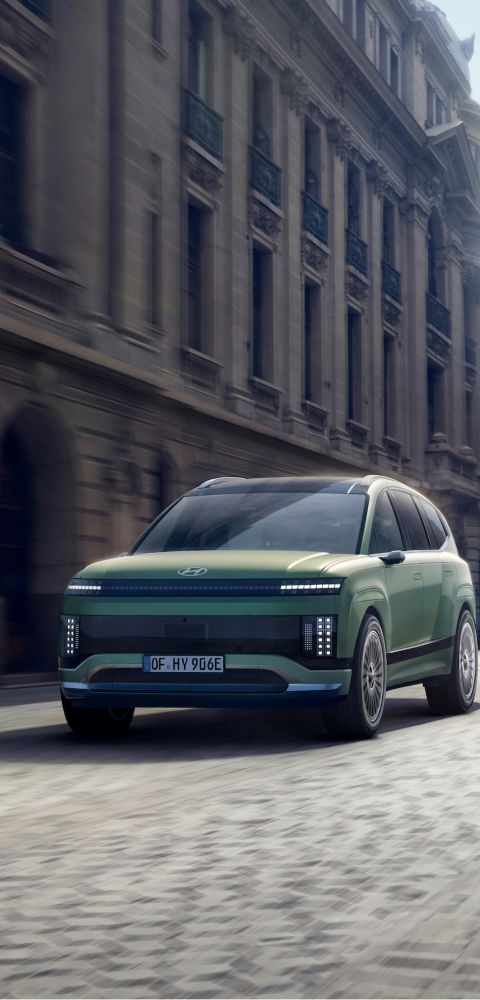 Three-quarter view of the Hyundai IONIQ 9 driving in the city.