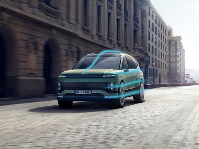 Hyundai IONIQ 9 driving through a city street with an aerodynamic flow graphic.