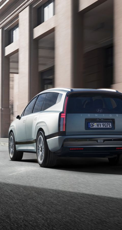 The rear view of the IONIQ 9 driving around town.