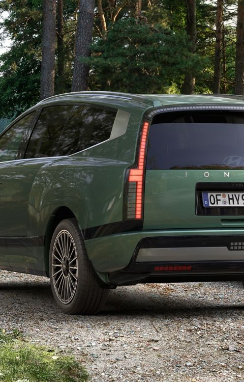 Rear view of the Hyundai IONIQ 9 electric SUV parked at a campsite.