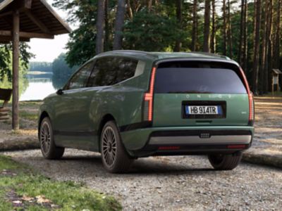 Visione posteriore del SUV elettrico Hyundai IONIQ 9 parcheggiata in un campeggio.