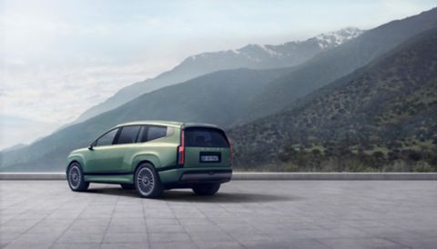 Vista trasera en 3/4 del Hyundai IONIQ 9 con montañas al fondo.
